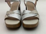 a close up of a pair of silver sandals on a white surface