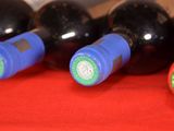 several bottles of wine are lined up on a red cloth