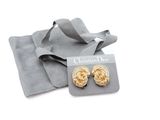 a pair of gold tone earrings with a gift bag