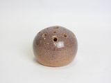 a brown ceramic ball with holes in it