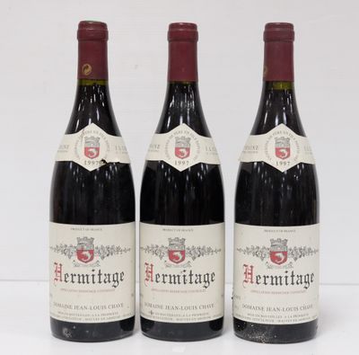 three bottles of red wine sitting on top of a white table