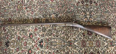 le fusil est posé sur le tapis, par terre