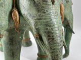 statue of a man riding on the back of an elephant with a basket on its back