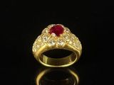 a close up of a gold ring with a red stone in the center