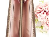 pink leather wallet with gold zipper and flower on white background