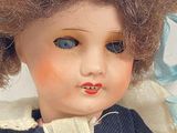 a close up of a doll wearing a blue dress