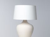 une lampe de table blanche surmontée d'un abat-jour blanc