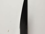 tall black vase on a white surface with a white wall in the background