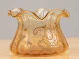 a glass vase with a gold design on it on a table