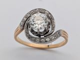 un gros plan d'une bague en diamant et en or sur fond blanc
