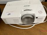 a small projector sitting on a table next to a laptop