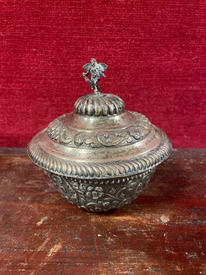 une assiette en argent antique avec un oiseau sur le dessus