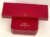 two red boxes with gold writing on them sitting on a white surface