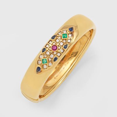 gros plan d'une bague en or avec des pierres multicolores