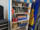 a blue and white striped cabinet with shelves and a black chair in front of it