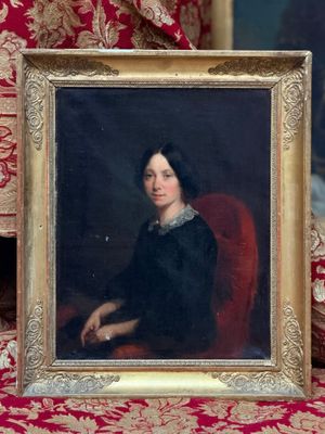 portrait d'une femme en robe noire, assise sur une chaise rouge