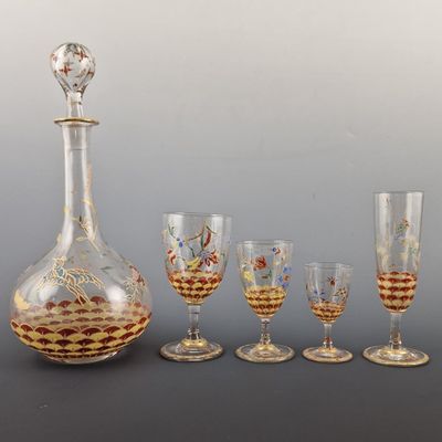 an assortment of wine glasses and a decanter on a table