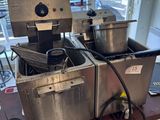 two deep fryers sitting on a table in a kitchen