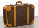 une valise marron et beige posée par terre