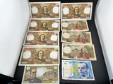 six billets de banque différents sont posés dans une boîte sur une table