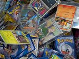 pile of pokemon cards in a cardboard box on a table