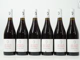 six bouteilles de vin sont alignées sur une table