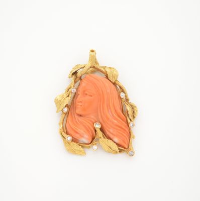 une image représentant une broche aux couleurs or et corail sur fond blanc