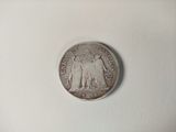 a silver coin with a picture of a man and a woman on it