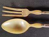 two forks and a spoon sitting on a table