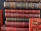 several old books are stacked on top of each other on a table