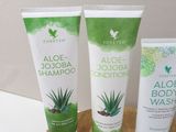 aloea jojoba shampoo and aloea shampoo on a wooden tray