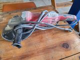 une ponceuse rose posée sur une table en bois, avec une chaise bleue