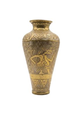 un vase doré orné d'un motif sur fond blanc