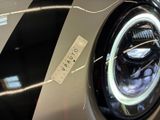 a close up of a car ' s headlight with a sticker on it