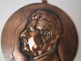 an old bronze medal with a picture of a man on it