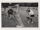 photographie en noir et blanc d'un homme tenant une batte de baseball, tandis qu'un autre homme tient une batte de baseball derrière lui