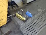 a padlock on the ground next to a yellow box