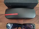 Lunettes de soleil Prada noires avec bordure rouge et étui