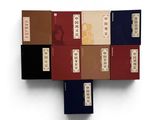six livres empilés les uns sur les autres sur une surface blanche