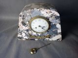 une horloge posée sur une table à côté d'une cuillère