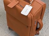 a brown suitcase sitting on the ground with a tag on it