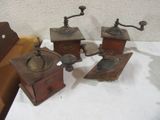 three old fashioned coffee grinders are sitting on a table