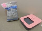 a pink plastic box and a bag of cat litter on a table