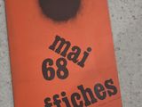 un livre orange avec un point noir dessus, posé par terre