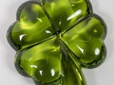 broche en verre vert en forme de trèfle à quatre feuilles sur un fond blanc