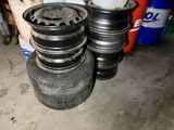 a lot of tires stacked on top of each other in a garage
