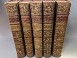 a set of five old books with gold and brown covers