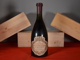 a bottle of wine sitting on a table next to a wooden box