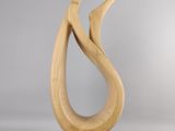 sculpture en bois représentant un oiseau, posée sur un socle en bois, sur fond gris