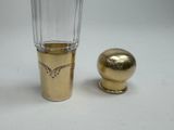 a glass and a gold vase sitting next to each other